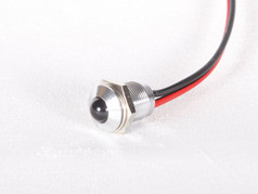 Silberne LED-Leuchte mit dunkler Linse und roten sowie schwarzen Kabeln.