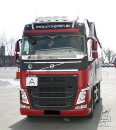 Frontansicht eines roten Volvo FH LKW mit montiertem, silbernem Scheibengitter mit gebogenen Kanten.