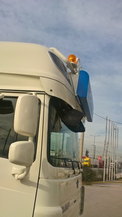 Montierte Edelstahl-Halterung f�r Leuchtkasten auf dem Dach eines wei�en DAF LKW, mit blauem Leuchtkasten.