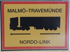 Gelber Aufkleber mit rotem Rand, schwarzem LKW-Symbol und den Texten Malm�-Travem�nde, Nordo-Link.