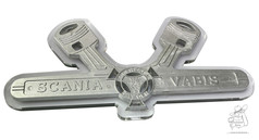 Silbernes Schild mit Kolben-Design, Scania Vabis Schriftzug und Greif-Emblem auf wei�em, beleuchtbarem Untergrund.