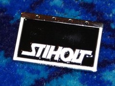 Ein rechteckiger Scandi Pin "Stiholt" mit gl�nzend schwarzem Feld, wei�er "STIHOLT" Schrift und silbernem Metallrand.