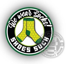 Runder Aufkleber mit gr�nen und gelben Socken mit Smileys und dem Text "We wear Socks! SHOES SUCK".