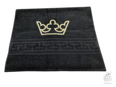 Schwarzes Handtuch mit gold-wei� gestickter Krone und geometrischem Musterband.