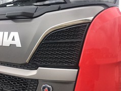 Edelstahl-Formteil am Scania NG LKW. Gl�nzende Zierleiste auf grauem und rotem Lack.