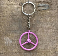 Ein rosa Old School Lenkrad Schl�sselanh�nger mit silbernem Schl�sselring und Kette, auf einer Holzoberfl�che.