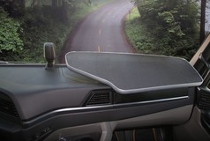 Grauer Beifahrertisch mit strukturierter Oberfl�che und silbernem Rand, im Innenraum eines LKW montiert.