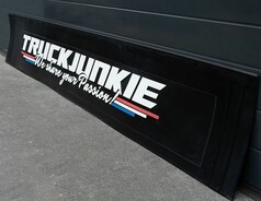 Schwarze Gummi-Hecksch�rze mit wei�em 3D-TRUCKJUNKIE Schriftzug, farbigen Streifen und Montagekante.