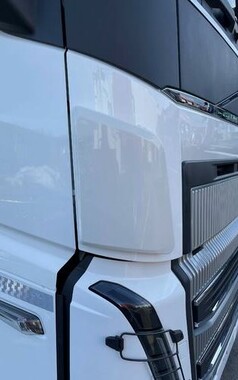 Wei�er Windabweiser aus gl�nzendem Kunststoff, montiert an der Front eines wei�en LKWs neben dem K�hlergrill.