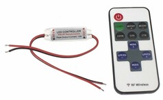 Ein wei�er LED-Dimmer mit roten und schwarzen Kabeln und eine wei�e Funkfernbedienung mit grauen Tasten.