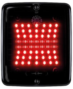 Schwarze, eckige Heckleuchte mit dunkler Linse und leuchtenden roten LEDs. Oben steht 