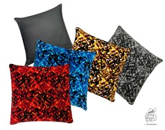 Verschiedene Pl�schkissen mit abstrakten Mustern in Rot, Blau, Gelb, Grau und ein Kissen mit schwarzer Stoffr�ckseite.