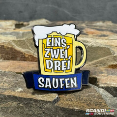 Emaille-Pin in Form eines Bierkrugs mit gelbem Krug, wei�em Schaum und blauem Banner. Aufschrift: EINS, ZWEI, DREI SAUFEN.