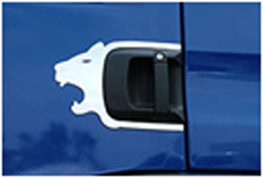 Silberne Edelstahlt�rgriffeinrahmung mit L�wenkopf an schwarzem T�rgriff einer blauen LKW-T�r.