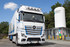 Der gl�nzende Kennzeichenhalter "Strong" mit LED ist an der Front eines wei�en Mercedes-Benz Actros MP4/MP5 LKW montiert.
