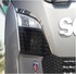 Gl�nzende lange B�gen am Scheinwerfer eines grauen Scania NG LKWs mit Scania Logo.